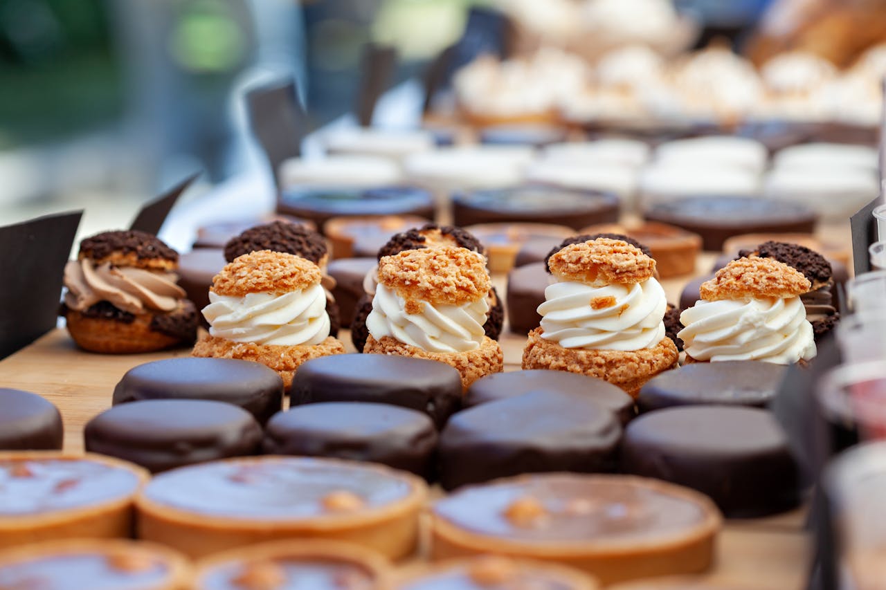A delectable array of gourmet pastries and desserts featuring creamy, chocolate, and nut toppings, perfect for indulgence.