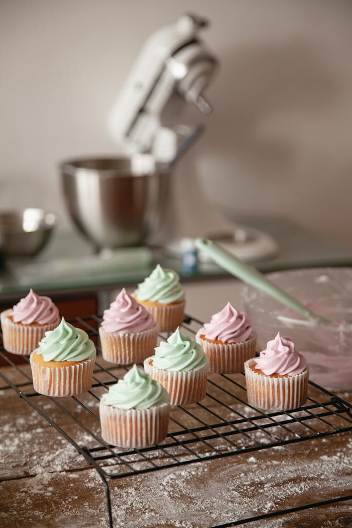 Freshly baked cupcakes with pastel frosting in a cozy kitchen setting.